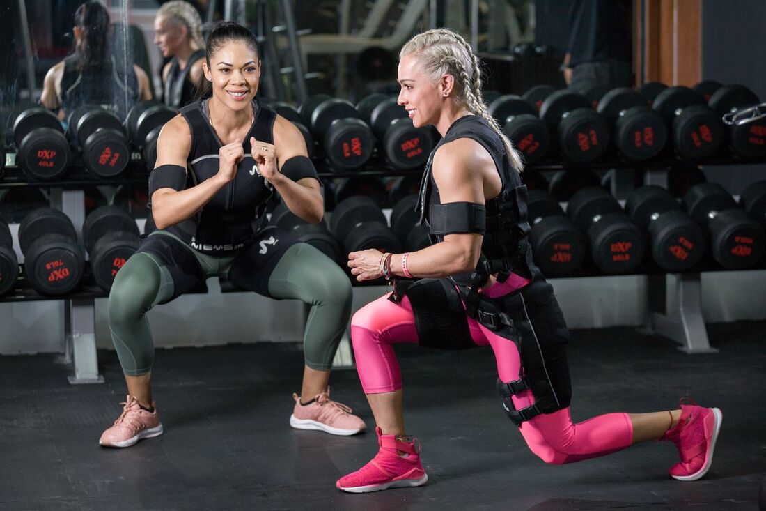 Personlig træner instruerer medlem i styrketræning i fitnessstudie i København