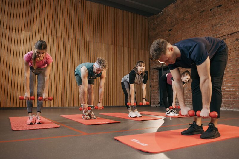 Instruktør leder holdtræning i moderne fitnessstudie i København