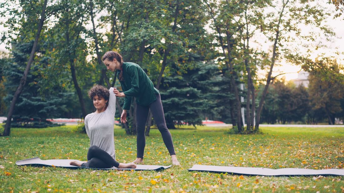 Instruktør der guider en yogatime for et hold i et københavnsk studie